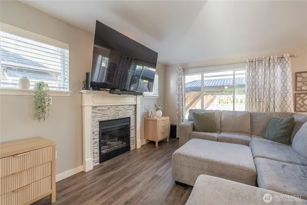 a living room with furniture a flat screen tv and a fireplace