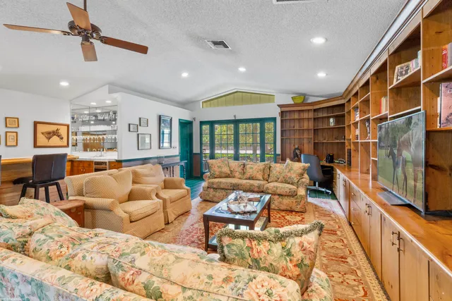 a living room with furniture a flat screen tv and a table