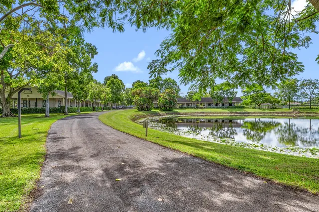 a view of a lake with a yard and large trees