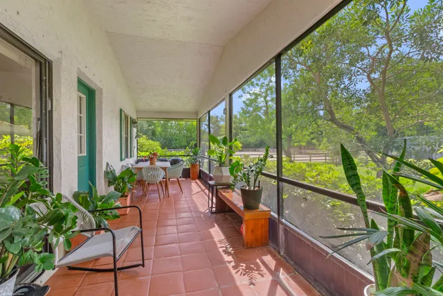 a view of a house with a big yard and palm trees