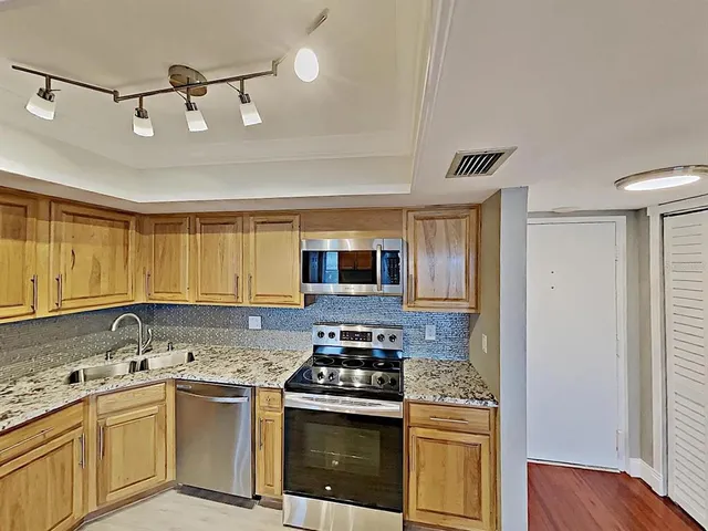 a kitchen with stainless steel appliances granite countertop a stove and a sink