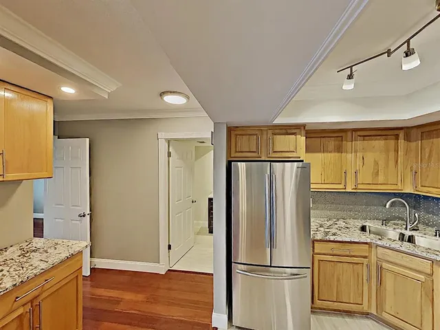 a kitchen with stainless steel appliances granite countertop a refrigerator and a sink