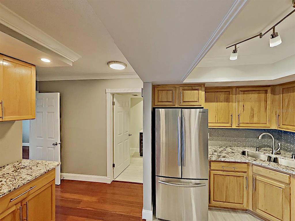 5220 Brittany Drive South, Unit 1502 St. Petersburg, FL 33715 - Photo 13 of 21 a kitchen with stainless steel appliances granite countertop a refrigerator and a sink