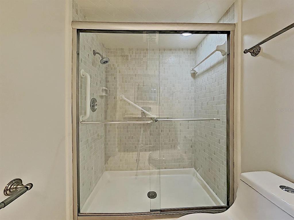 5220 Brittany Drive South, Unit 1502 St. Petersburg, FL 33715 - Photo 17 of 21 a bathroom with a shower and toilet