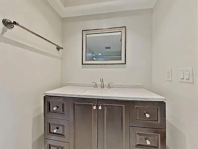 a view of a sink a mirror and cabinets