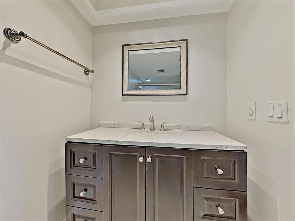 5220 Brittany Drive South, Unit 1502 St. Petersburg, FL 33715 - Photo 18 of 21 a view of a sink a mirror and cabinets