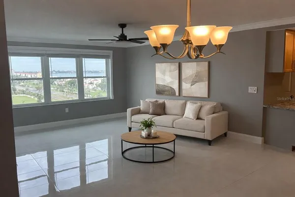 a living room with furniture a chandelier and a window
