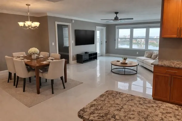 a living room with furniture a flat screen tv and a large window