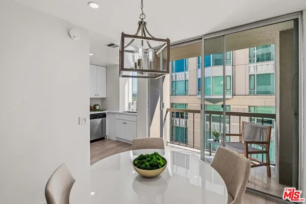 a kitchen with stainless steel appliances a refrigerator a sink a stove and white cabinets