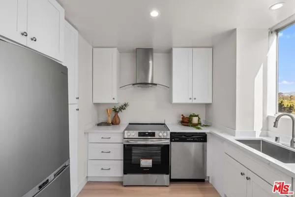 a kitchen with stainless steel appliances granite countertop a sink stove and cabinets