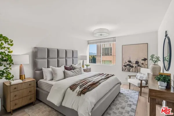 a spacious bedroom with a bed and a potted plant