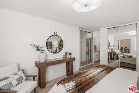 a bedroom with a bed a mirror and a window