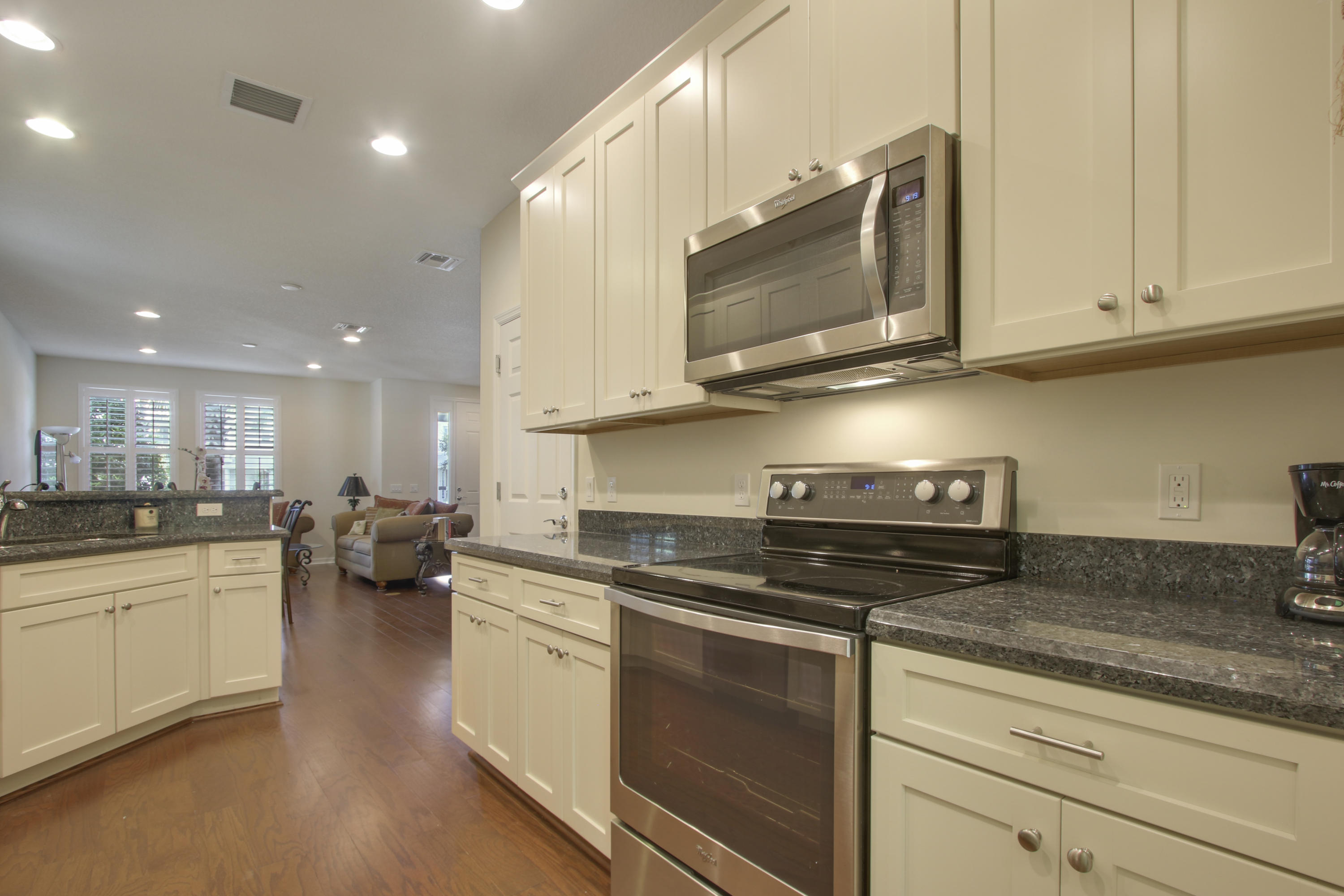 1168 South Community Drive Jupiter, FL 33458 - Photo 7 of 18 a kitchen with stainless steel appliances granite countertop a sink a stove top oven and white cabinets