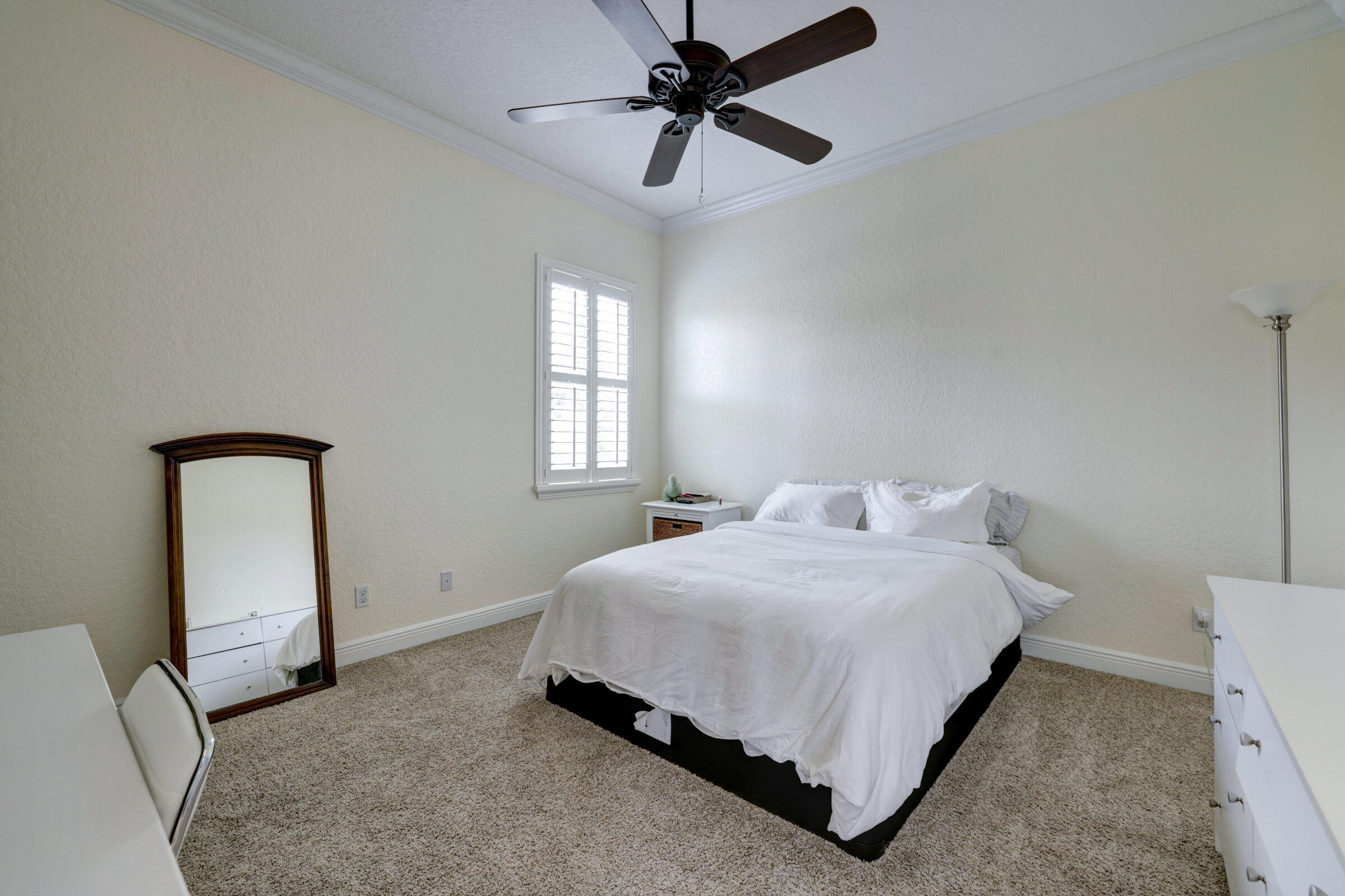 571 Southeast Tres Belle Circle Stuart, FL 34997 - Photo 18 of 54 a bedroom with a bed lamp and window