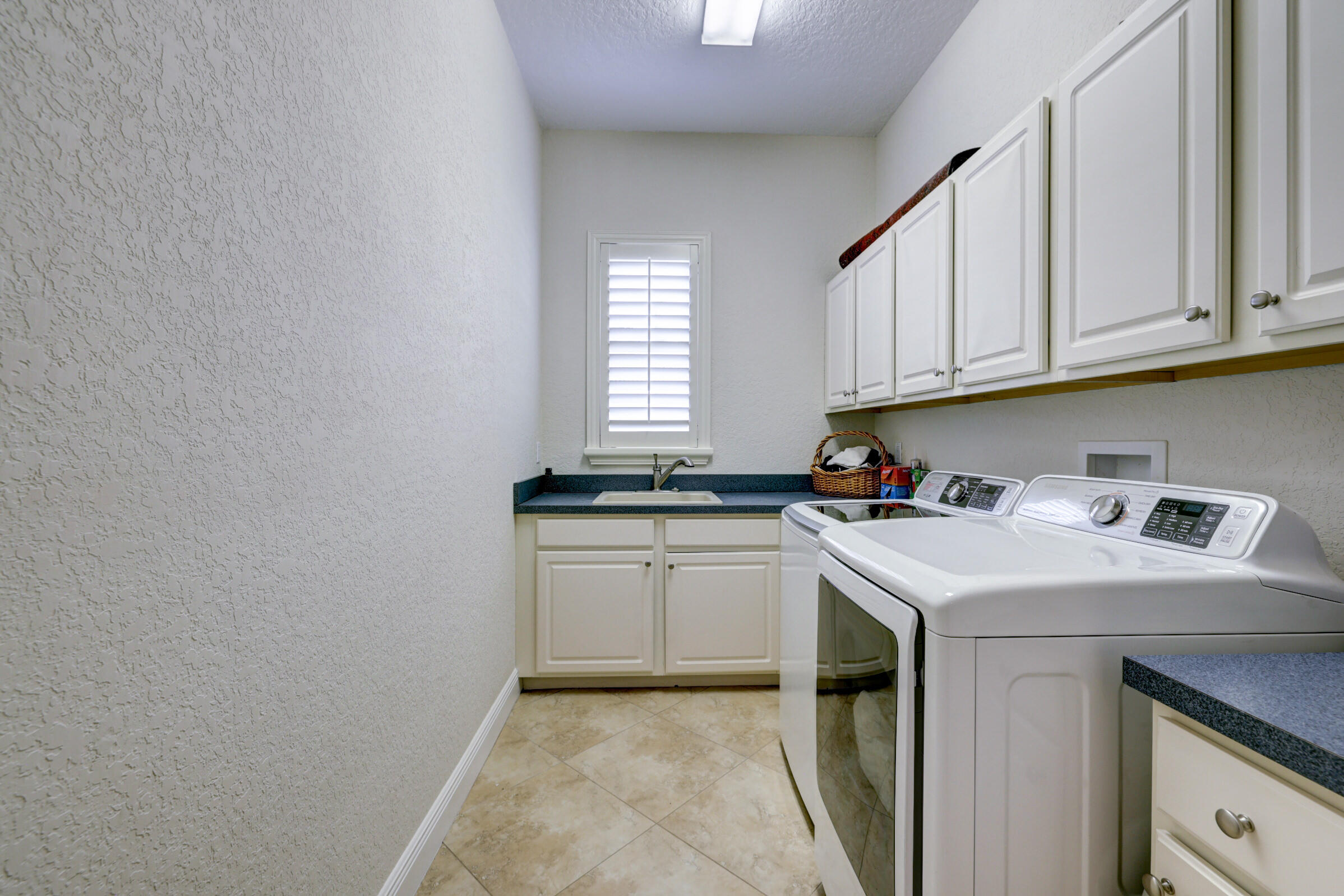 571 Southeast Tres Belle Circle Stuart, FL 34997 - Photo 29 of 54 a utility room with sink washer and dryer