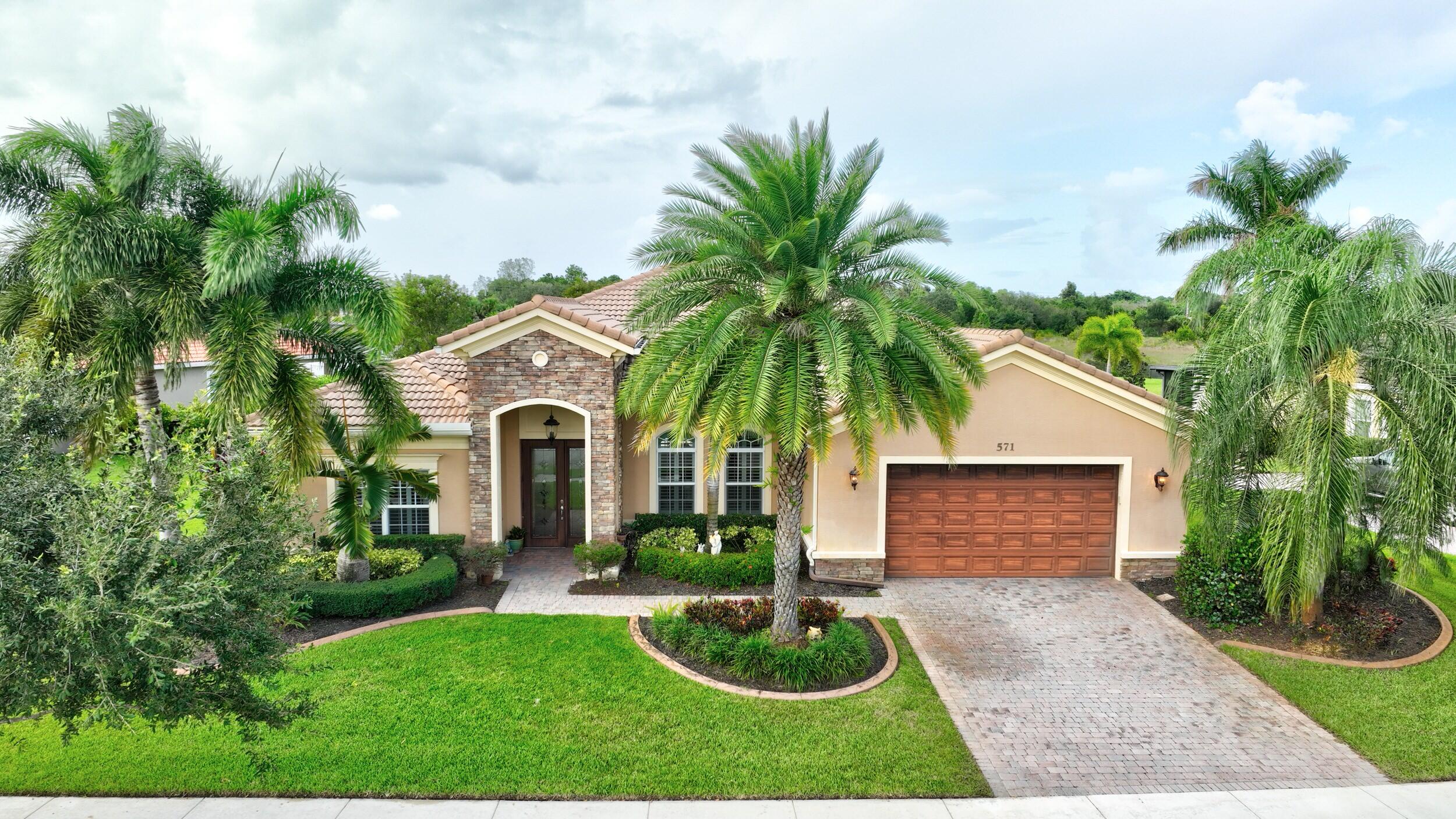 571 Southeast Tres Belle Circle Stuart, FL 34997 - Photo 42 of 54 a front view of a house with yard and green space