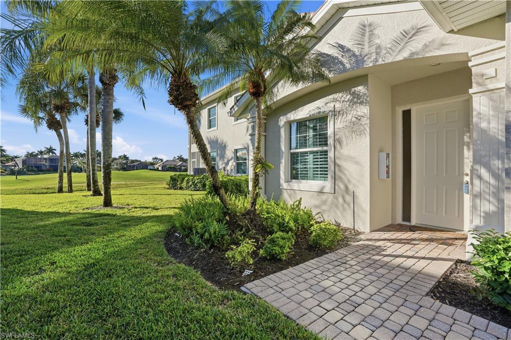 5963 Trophy Drive, Unit 2003 Naples, FL 34110 - Photo 13 of 50 Doorway to property featuring a yard and stucco siding