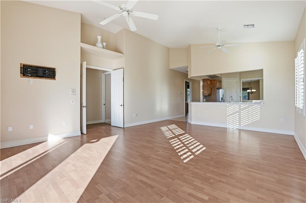5963 Trophy Drive, Unit 2003 Naples, FL 34110 - Photo 27 of 50 Unfurnished living room with light wood-style flooring, high vaulted ceiling, and a ceiling fan
