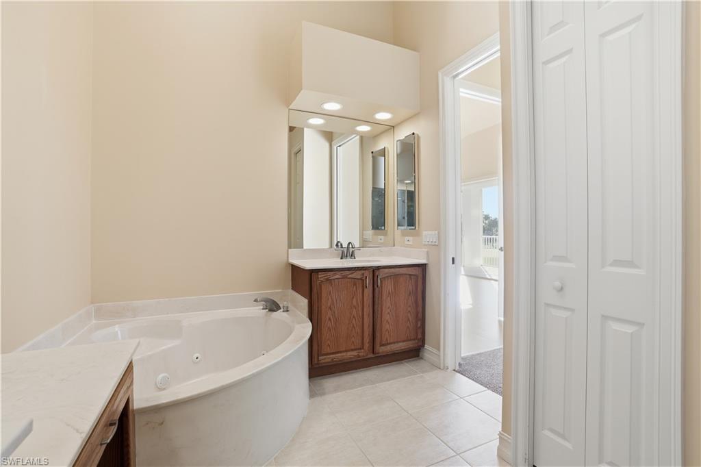 5963 Trophy Drive, Unit 2003 Naples, FL 34110 - Photo 35 of 50 Full bath featuring vanity, a jetted tub, light tile patterned floors, recessed lighting, and a closet