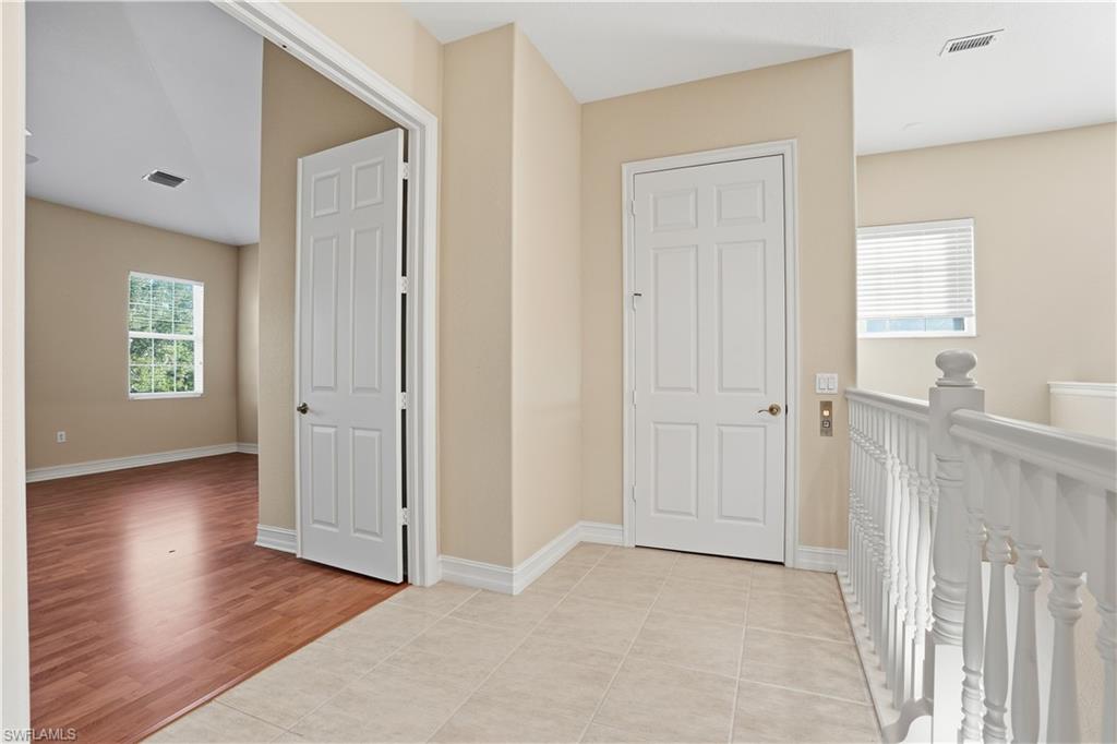 5963 Trophy Drive, Unit 2003 Naples, FL 34110 - Photo 38 of 50 Hall with light tile patterned flooring and an upstairs landing