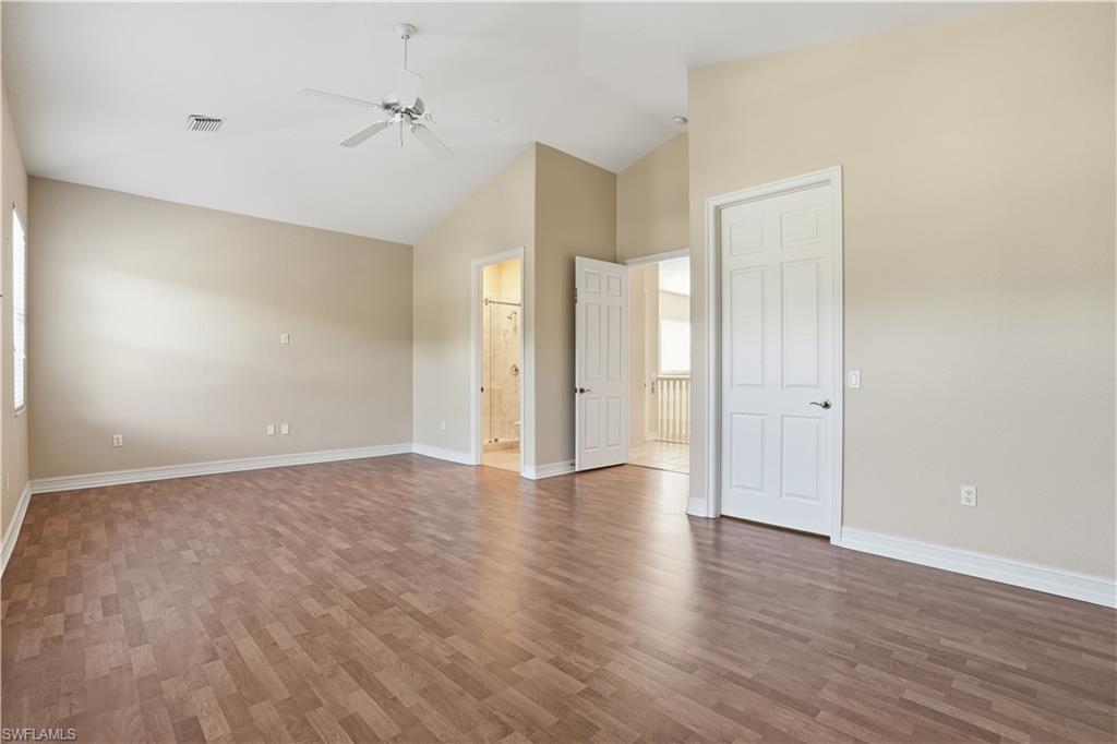 5963 Trophy Drive, Unit 2003 Naples, FL 34110 - Photo 40 of 50 Unfurnished bedroom with vaulted ceiling, wood finished floors, a ceiling fan, and ensuite bathroom