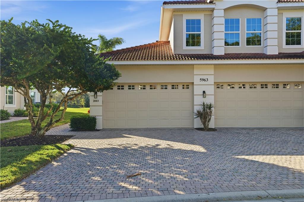 5963 Trophy Drive, Unit 2003 Naples, FL 34110 - Photo 49 of 50 View of front of house featuring a tiled roof, stucco siding, decorative driveway, and a garage