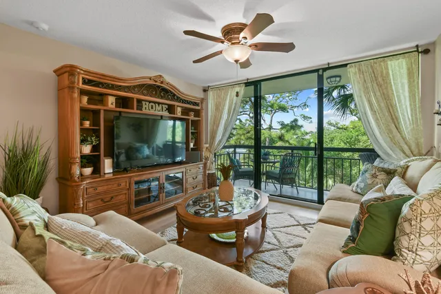 a living room with furniture a large window and a flat screen tv