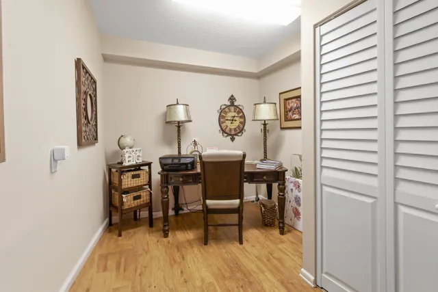 a view of a workspace with furniture and wooden floor