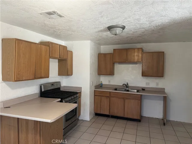 a kitchen with a sink a stove cabinets and a dining table