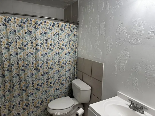 a white toilet sitting next to a shower curtain
