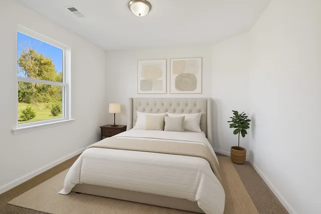 a bedroom with a bed and a painting on the wall