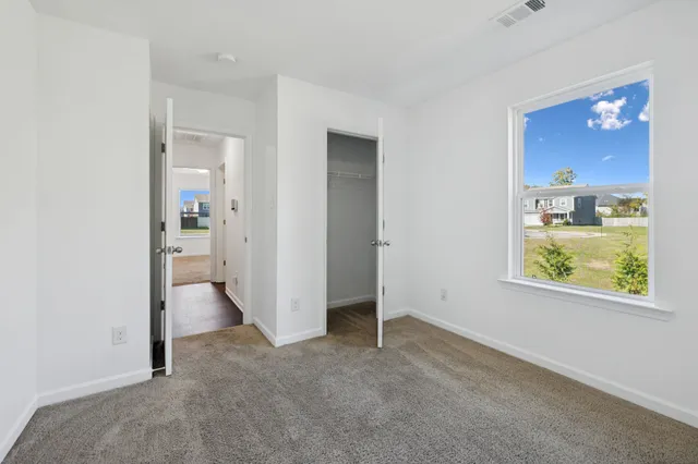 an empty room that has a wooden door and windows