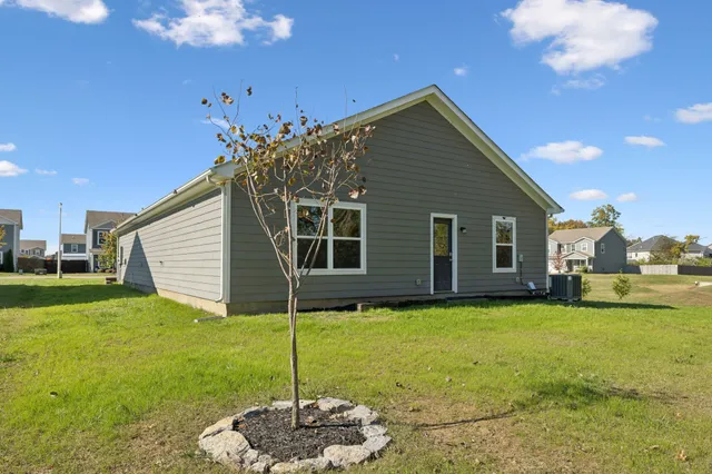 a backyard of a house with table and chairs