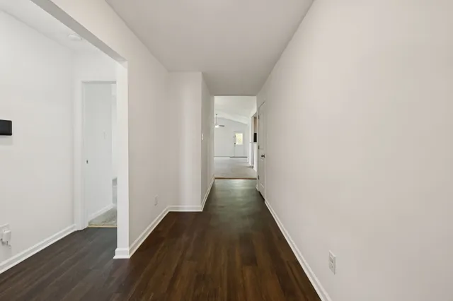 a view of a hallway with wooden floor