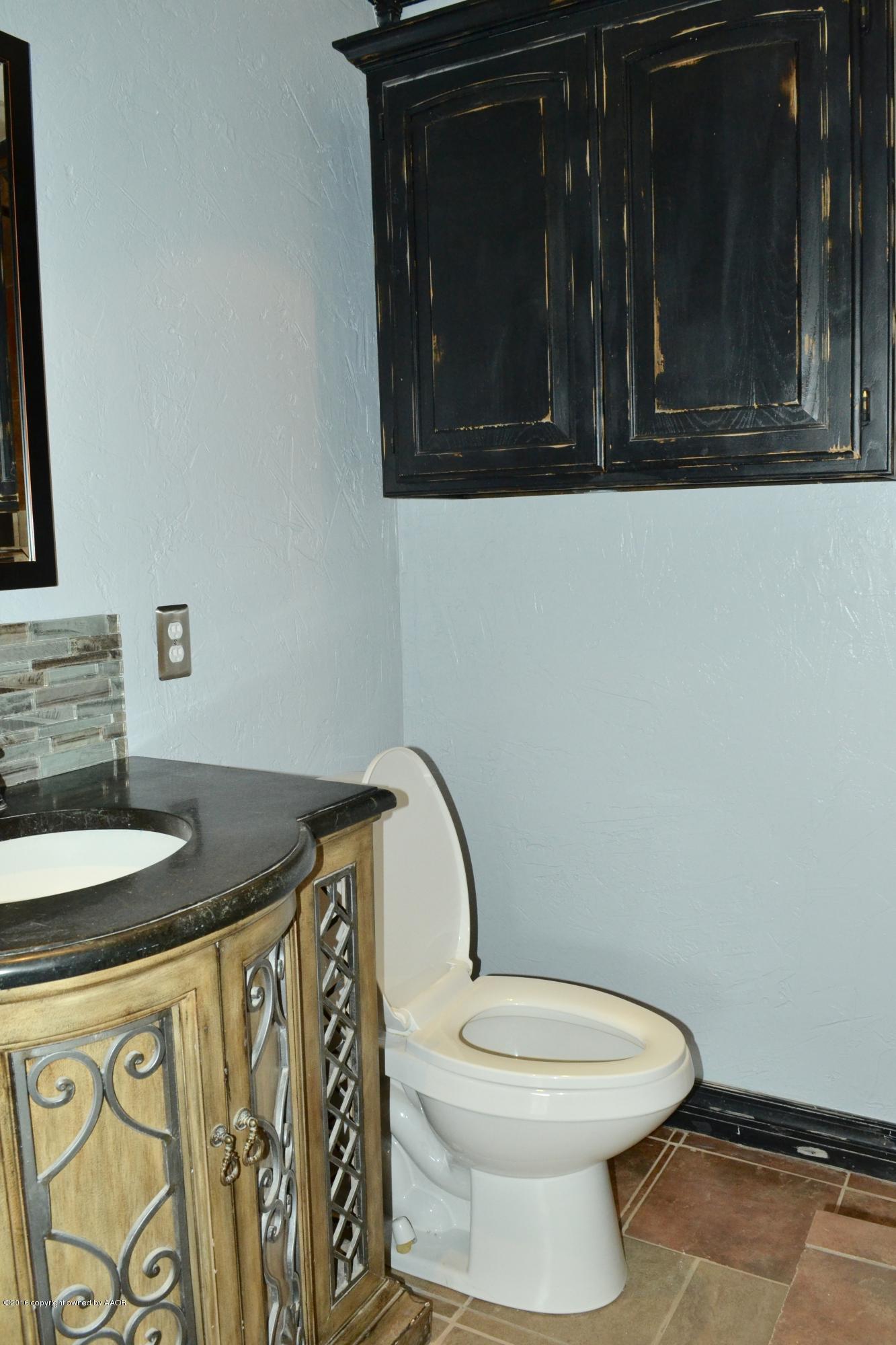 4004 South Lipscomb Street Amarillo, TX 79110 - Photo 34 of 49 a bathroom with a granite countertop toilet sink and mirror