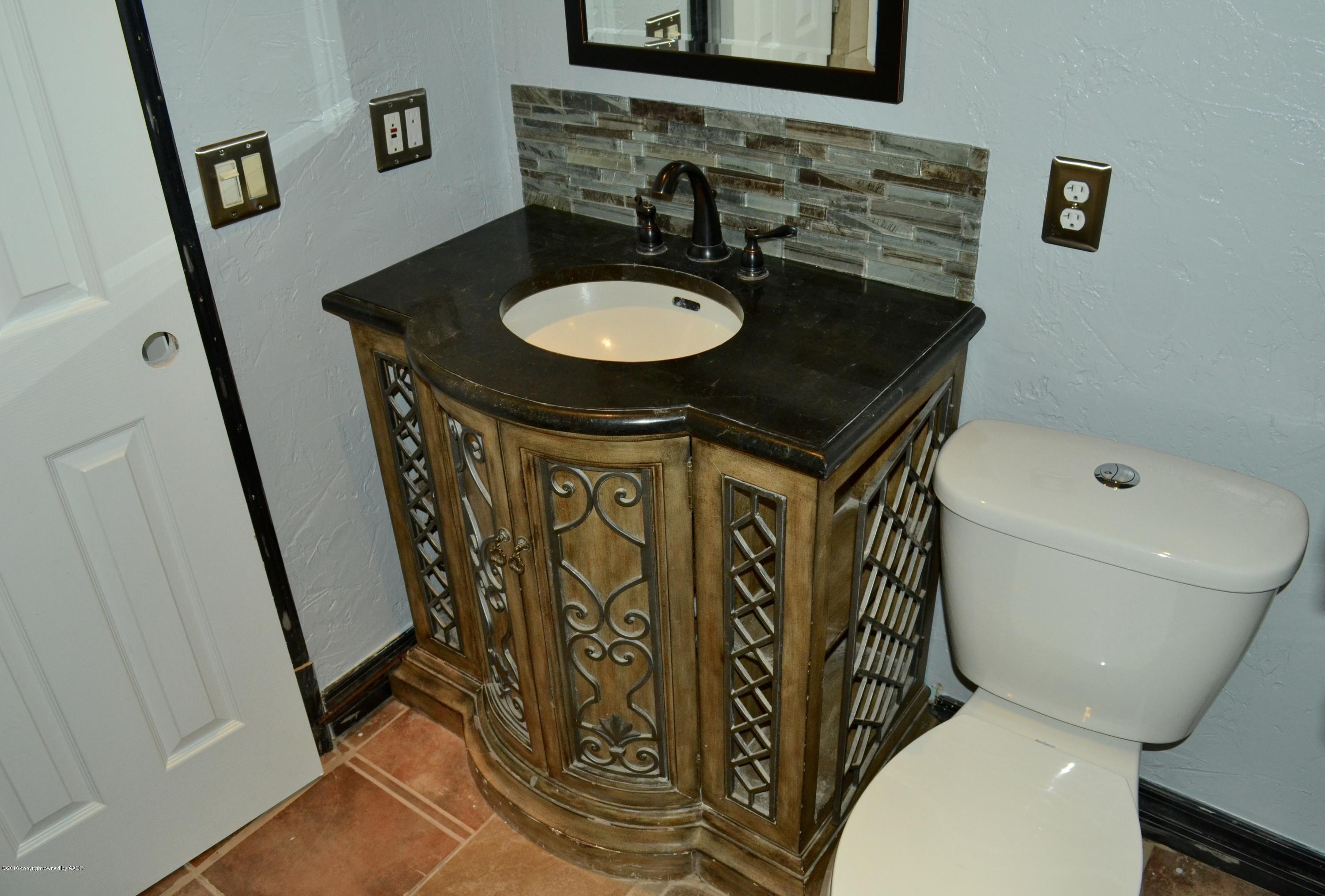 4004 South Lipscomb Street Amarillo, TX 79110 - Photo 39 of 49 a bathroom with a granite countertop toilet sink and mirror