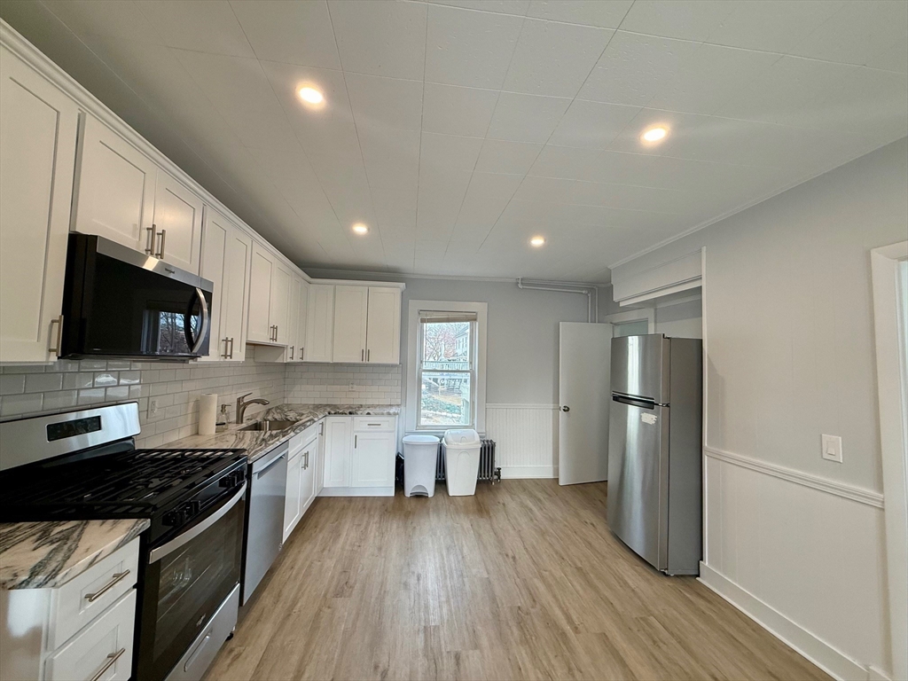 56 Lincoln Road, Unit 56 Newton, MA 02458 - Photo 2 of 10 a kitchen with a sink stainless steel appliances and cabinets