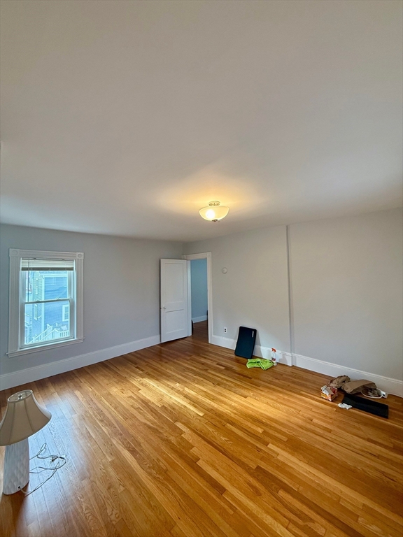 56 Lincoln Road, Unit 56 Newton, MA 02458 - Photo 7 of 10 a room with a bed and wooden floor