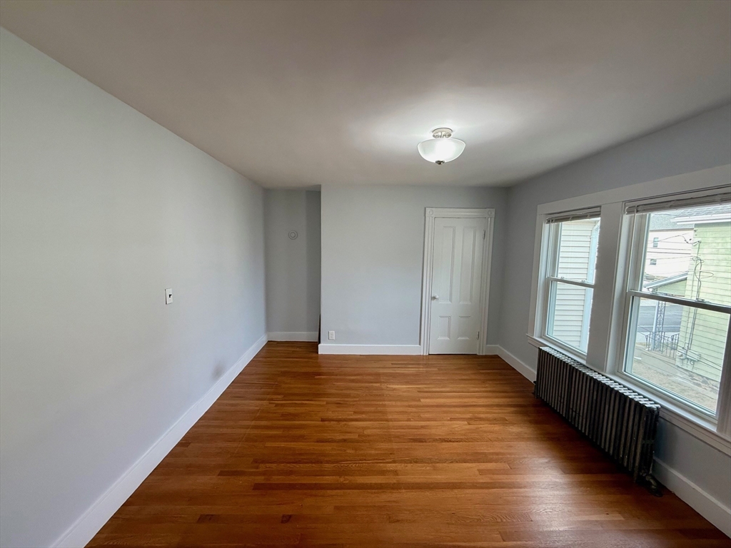 56 Lincoln Road, Unit 56 Newton, MA 02458 - Photo 9 of 10 a view of an empty room with wooden floor and a window
