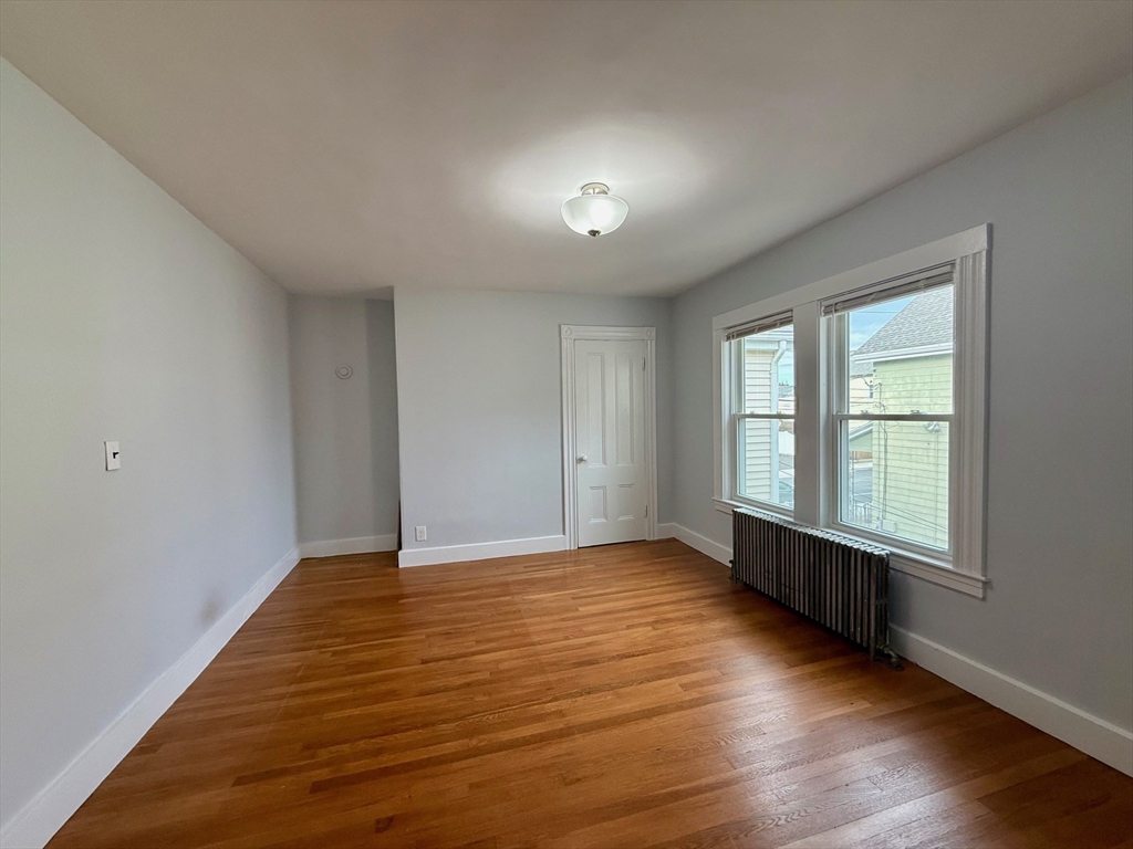 56 Lincoln Road, Unit 56 Newton, MA 02458 - Photo 10 of 10 a view of an empty room with wooden floor and a window