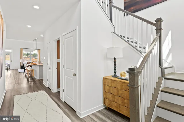 a view of a hallway with wooden floor and staircase