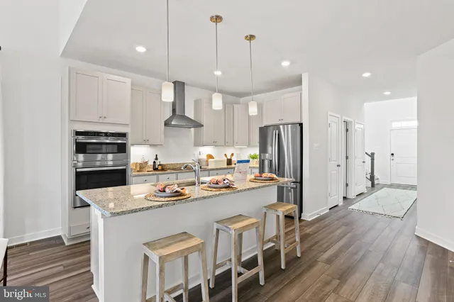 a kitchen with stainless steel appliances granite countertop a sink refrigerator and cabinets