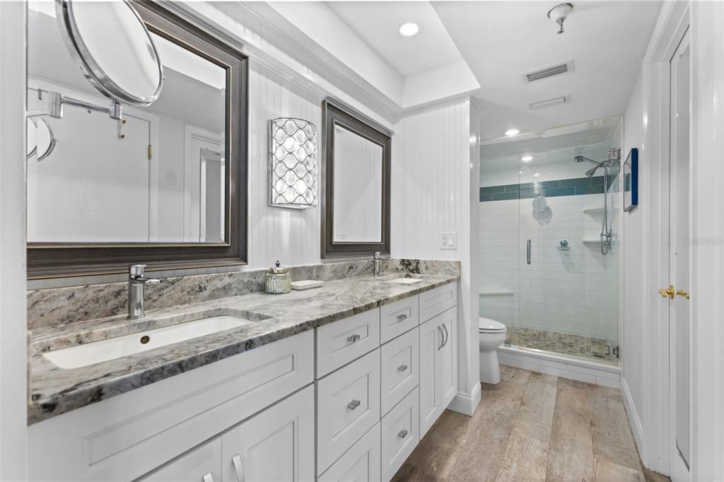 16332 Gulf Boulevard, Unit 2B Redington Beach, FL 33708 - Photo 28 of 60 a bathroom with a granite countertop sink mirror and a bathtub