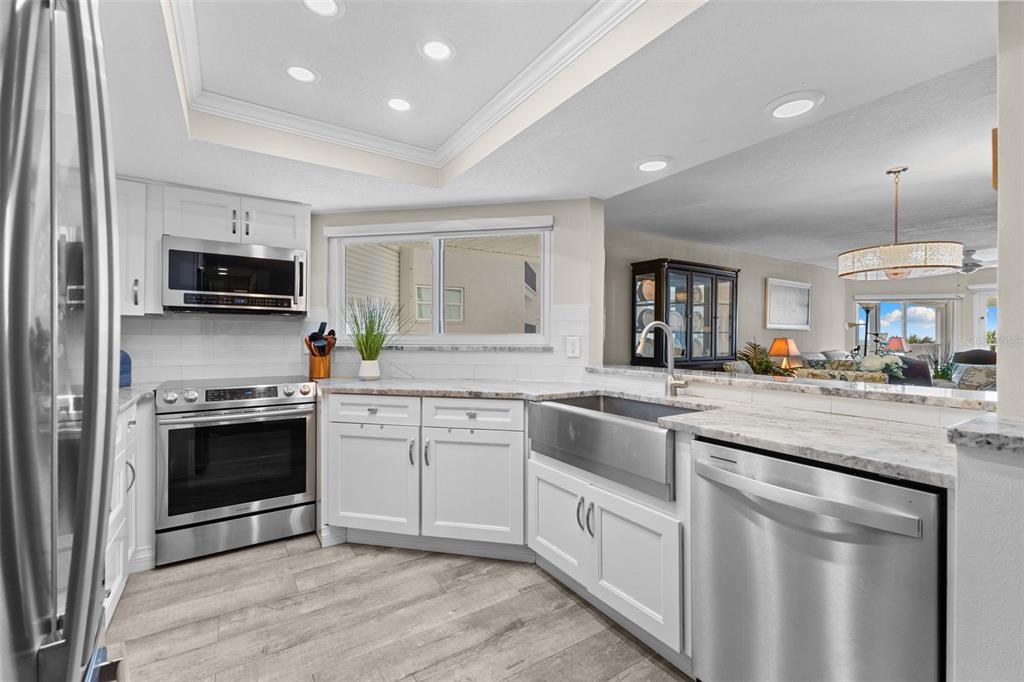 16332 Gulf Boulevard, Unit 2B Redington Beach, FL 33708 - Photo 3 of 60 a kitchen with granite countertop a sink stainless steel appliances and cabinets