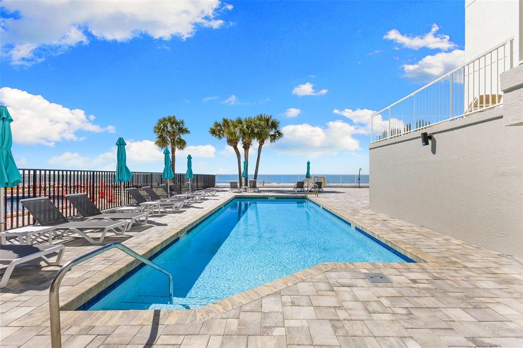 16332 Gulf Boulevard, Unit 2B Redington Beach, FL 33708 - Photo 5 of 60 a view of a swimming pool with a lounge chairs