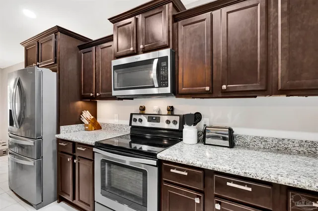 a kitchen with stainless steel appliances granite countertop a stove microwave and refrigerator