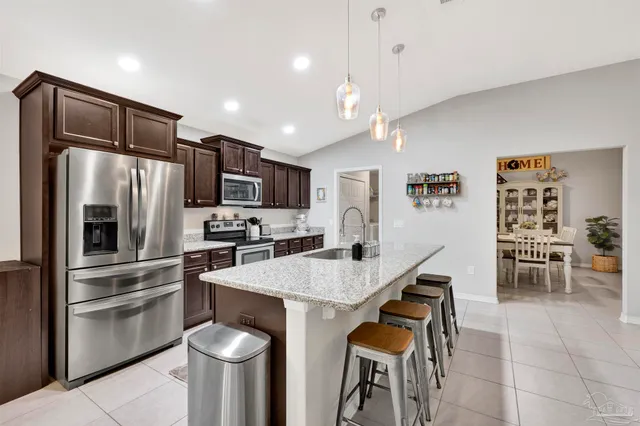 a kitchen with granite countertop a sink appliances cabinets and furniture