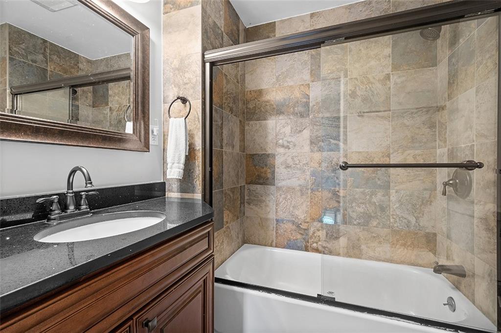 1815 Main Street Bridgeville, PA 15017 - Photo 14 of 32 a bathroom with a granite countertop sink a mirror and shower