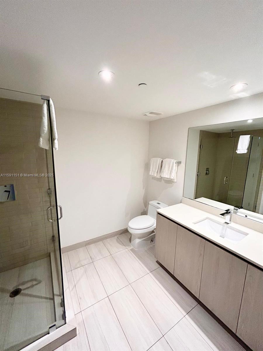 4010 South Ocean Drive, Unit R2407 Hollywood, FL 33019 - Photo 18 of 33 a spacious bathroom with a double vanity sink toilet and a mirror