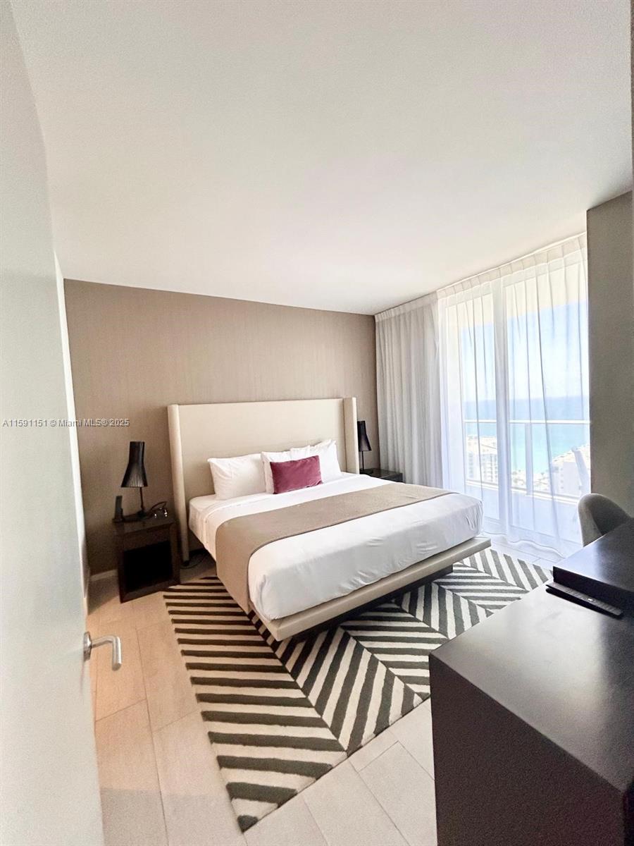 4010 South Ocean Drive, Unit R2407 Hollywood, FL 33019 - Photo 20 of 33 a bedroom with a bed and a large window